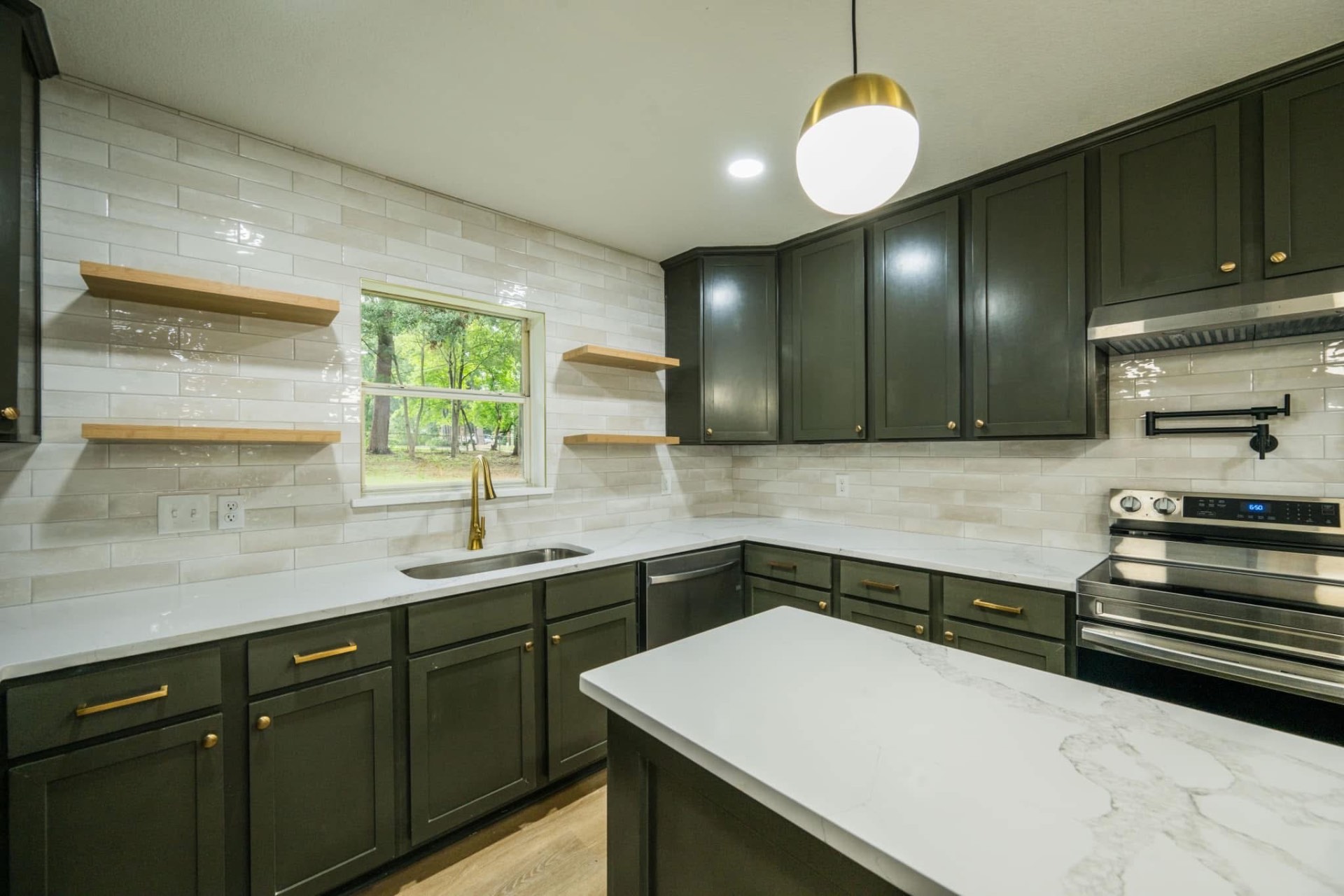 Completed Keystone kitchen renovation with dark green cabinetry and white countertops
