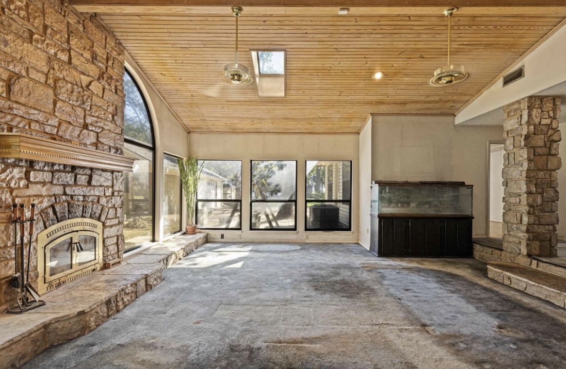 Living room — stone fireplace and existing finishes · Before renovation · Longview, Texas