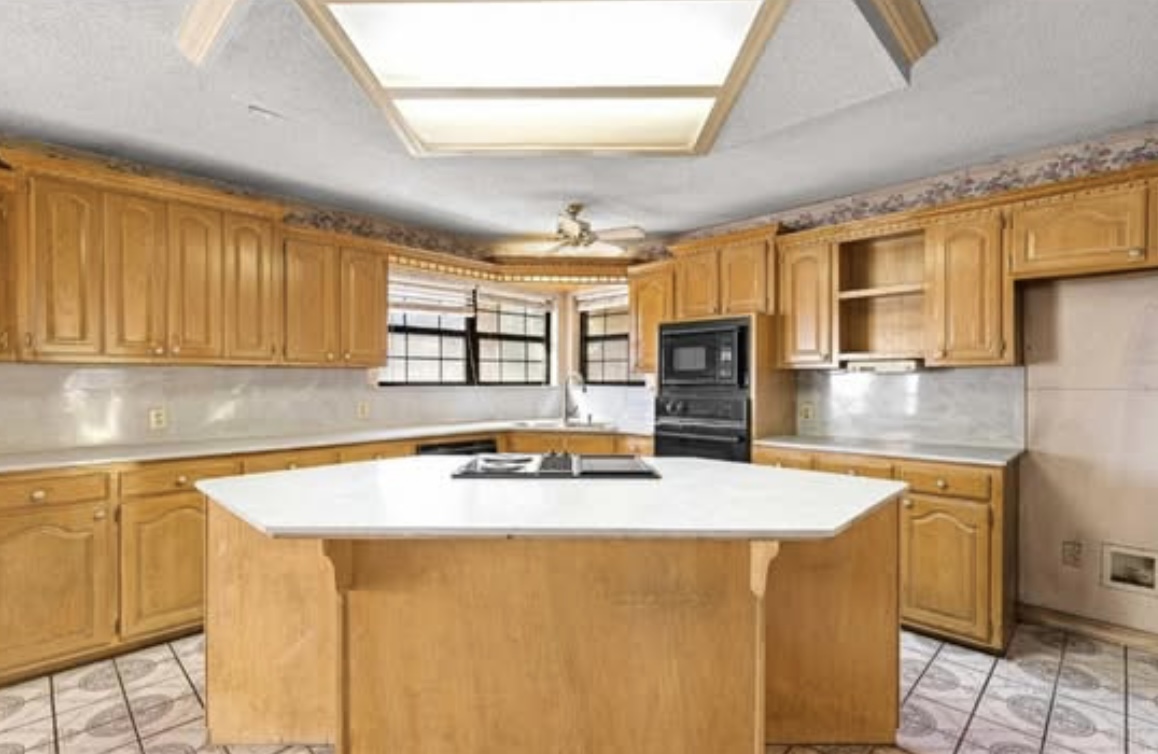 Kitchen — wood cabinetry and island · Before renovation · Longview, Texas